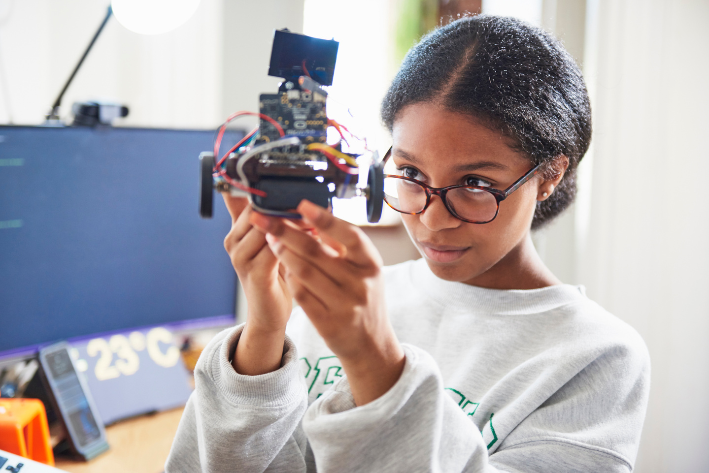 teenage girl building robot